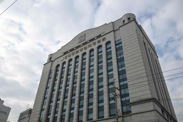The emblem of Unification Church with Korean words reading "Family Federation for World Peace and Unification" is seen on the exterior of the church's headquarters in Seoul on December 15, 2025. South Korean police raided the headquarters of the cult-like Unification church on December 15, and named its leader as a suspect in the bribery of several high-profile politicians. (Photo by Jung Yeon-je / AFP)
