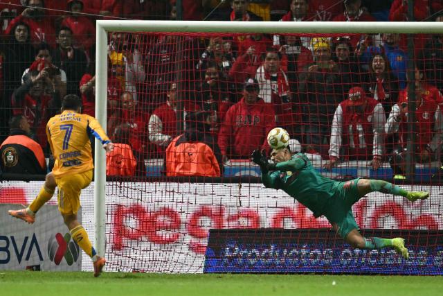 TOPSHOT - Toluca's goalkeeper #22 Luis Garcia makes a save past Tigres' Argentine forward #07 Angel Correa during the penalty shootout of the Liga MX Apertura final second leg football match between Toluca and Tigres at the Nemesio Diez stadium in Toluca, Mexico on December 14, 2025. (Photo by Yuri CORTEZ / AFP)