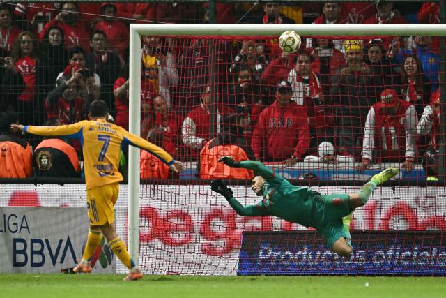 Toluca's goalkeeper #22 Luis Garcia makes a save past Tigres' Argentine forward #07 Angel Correa during the penalty shootout of the Liga MX Apertura final second leg football match between Toluca and Tigres at the Nemesio Diez stadium in Toluca, Mexico on December 14, 2025. (Photo by Yuri CORTEZ / AFP)