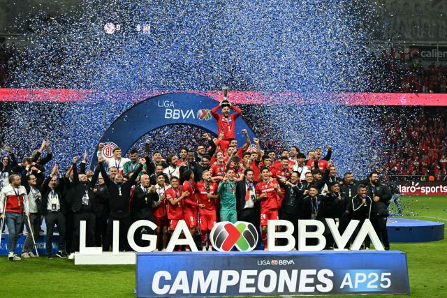 Toluca's forward #09 Alexis Vega lifts the trophy next to teammates after winning the Liga MX Apertura final second leg football match between Toluca and Tigres at the Nemesio Diez stadium in Toluca, Mexico on December 14, 2025. (Photo by YURI CORTEZ / AFP)
