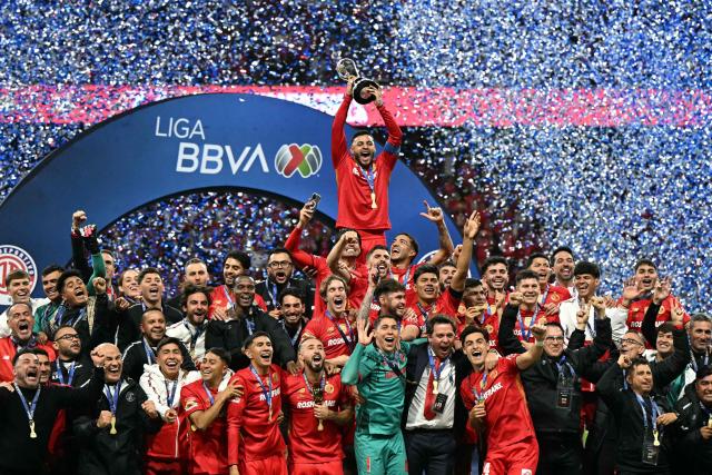 Toluca's forward #09 Alexis Vega lifts the trophy next to teammates after winning the Liga MX Apertura final second leg football match between Toluca and Tigres at the Nemesio Diez stadium in Toluca, Mexico on December 14, 2025. (Photo by YURI CORTEZ / AFP)