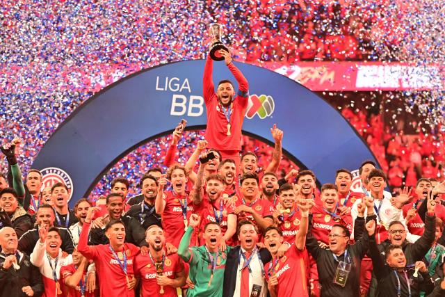 Toluca's forward #09 Alexis Vega lifts the trophy next to teammates after winning the Liga MX Apertura final second leg football match between Toluca and Tigres at the Nemesio Diez stadium in Toluca, Mexico on December 14, 2025. (Photo by Mario Vazquez / AFP)