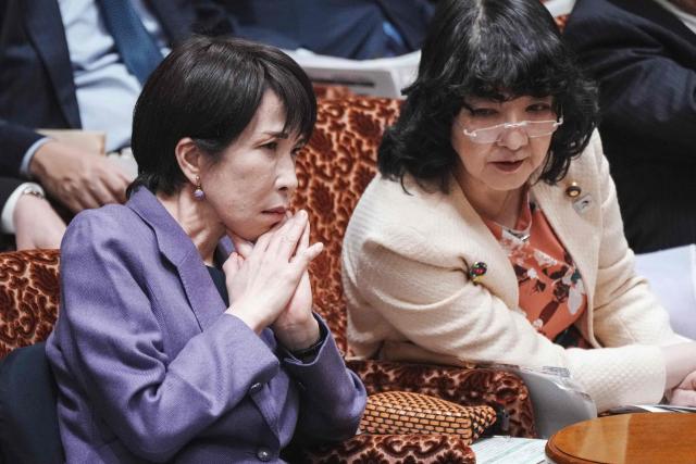 Japan's Prime Minister Sanae Takaichi (L) chats with Finance Minister Satsuki Katayama (R) during a session of the House of Councillors budget committee in the National Diet in Tokyo on December 15, 2025. (Photo by Kazuhiro NOGI / AFP)