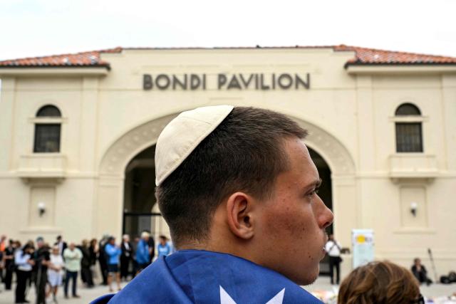 Mourners gather to pay a floral tribute to Bondi Beach shooting victims at the Bondi Pavilion in Sydney on December 15, 2025. A father-and-son team toting long-barrelled guns shot and killed 15 people including a 10-year-old girl at Sydney's Bondi Beach on December 14, with authorities labelling it an antisemitic terrorist attack on a Jewish festival. (Photo by Saeed KHAN / AFP)