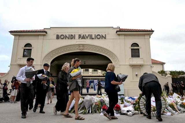 Mourners pay a floral tribute to Bondi Beach shooting victims at the Bondi Pavilion in Sydney on December 15, 2025. A father-and-son team toting long-barrelled guns shot and killed 15 people including a 10-year-old girl at Sydney's Bondi Beach on December 14, with authorities labelling it an antisemitic terrorist attack on a Jewish festival. (Photo by Saeed KHAN / AFP)