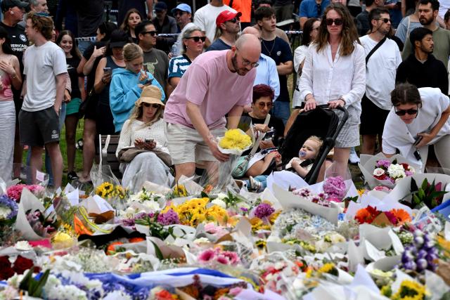 Mourners pay a floral tribute to Bondi Beach shooting victims at the Bondi Pavilion in Sydney on December 15, 2025. A father-and-son team toting long-barrelled guns shot and killed 15 people including a 10-year-old girl at Sydney's Bondi Beach on December 14, with authorities labelling it an antisemitic terrorist attack on a Jewish festival. (Photo by Saeed KHAN / AFP)