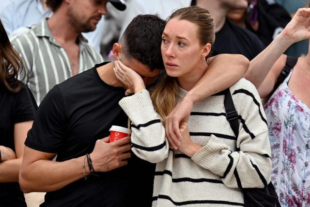 Mourners gather to pay a floral tribute to Bondi Beach shooting victims at the Bondi Pavilion in Sydney on December 15, 2025. A father-and-son team toting long-barrelled guns shot and killed 15 people including a 10-year-old girl at Sydney's Bondi Beach on December 14, with authorities labelling it an antisemitic terrorist attack on a Jewish festival. (Photo by Saeed KHAN / AFP)