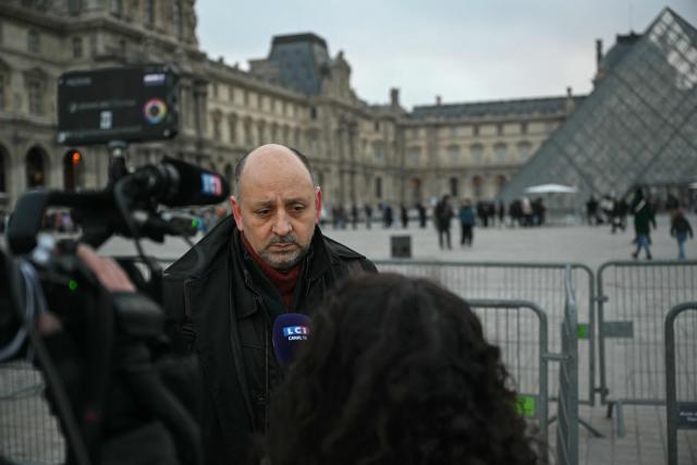 French CGT Union representative Christian Galani addresses the media outside the Louvre Museum as museum workers meet in a general assembly to vote on unions' call for an open-ended strike against increasingly deteriorating working conditions and the declining visitor experience at the world famous museum, in Paris on December 15, 2025. (Photo by Blanca CRUZ / AFP)