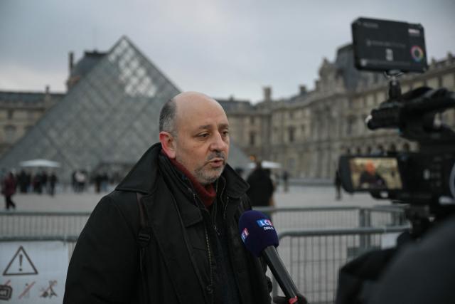 French CGT Union representative Christian Galani addresses the media outside the Louvre Museum as museum workers meet in a general assembly to vote on unions' call for an open-ended strike against increasingly deteriorating working conditions and the declining visitor experience at the world famous museum, in Paris on December 15, 2025. (Photo by Blanca CRUZ / AFP)