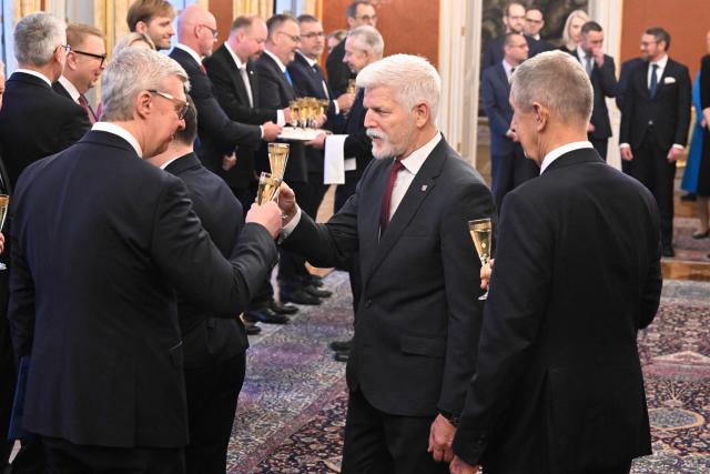 Czech President Petr Pavel (C) toasts a champagne with Czech Prime Minister Andrej Babis (R) and the newly appointed member of the Czech government Karel Havlicek (L) after Pavel appointed the new cabinet on December 15, 2025 at the Hradcany Castle in Prague, Czech Republic. (Photo by Michal Cizek / AFP)