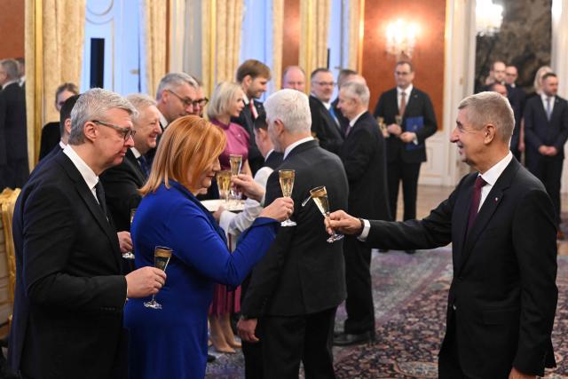 Czech Prime Minister Andrej Babis (R) toasts a champagne with the newly appointed members of the Czech government Karel Havlicek (L) and Alena Schillerova (2nd L) after Czech President Petr Pavel (C, background) appointed the new cabinet on December 15, 2025 at the Hradcany Castle in Prague, Czech Republic. (Photo by Michal Cizek / AFP)