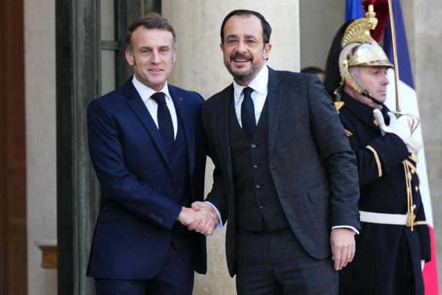 France's President Emmanuel Macron (L) greets Cyprus' President Nikos Christodoulides prior to their meeting at the Elysee Palace in Paris, on December 15, 2025. (Photo by Dimitar DILKOFF / AFP)