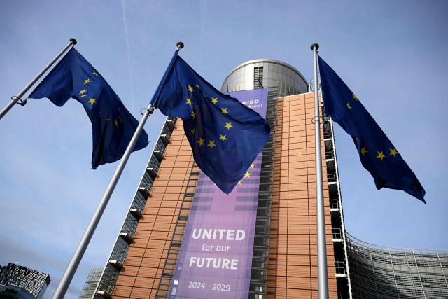 (FILES) This photograph shows European flags fluttering in front of the Berlaymont building, the EU Commission headquarters in Brussels on December 2, 2025. The European Commission said on December 15, 2025 it still expects to ink the EU's trade deal with South American bloc Mercosur by the end of the year, despite last-ditch efforts from France to derail the signing. (Photo by Nicolas TUCAT / AFP)