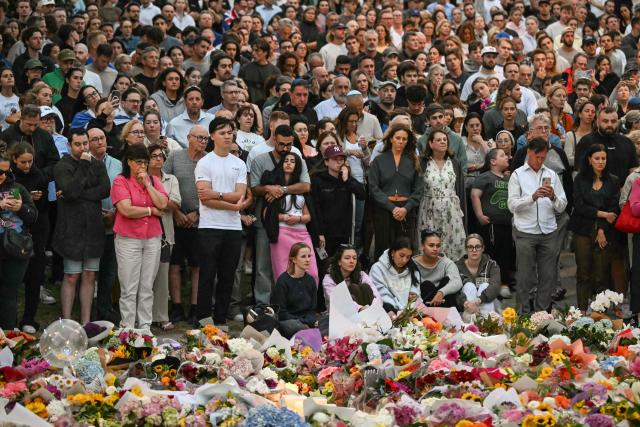 Mourners gather at a tribute at the Bondi Pavillion in memory of the victims of a shooting at Bondi Beach, in Sydney on December 15, 2025. A father and son opened fire on a Jewish festival at Australia's Bondi Beach in a shooting spree that killed 15 people, including a child, authorities said on December 15, denouncing the attack as antisemitic "terrorism". (Photo by Saeed KHAN / AFP)
