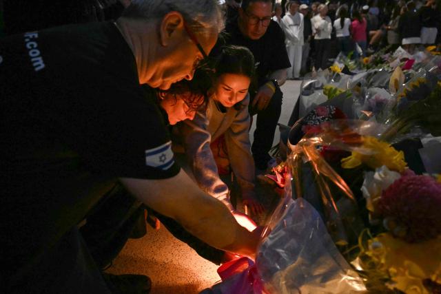 Mourners gather at a tribute at the Bondi Pavillion in memory of the victims of a shooting at Bondi Beach, in Sydney on December 15, 2025. A father and son opened fire on a Jewish festival at Australia's Bondi Beach in a shooting spree that killed 15 people, including a child, authorities said on December 15, denouncing the attack as antisemitic "terrorism". (Photo by Saeed KHAN / AFP)