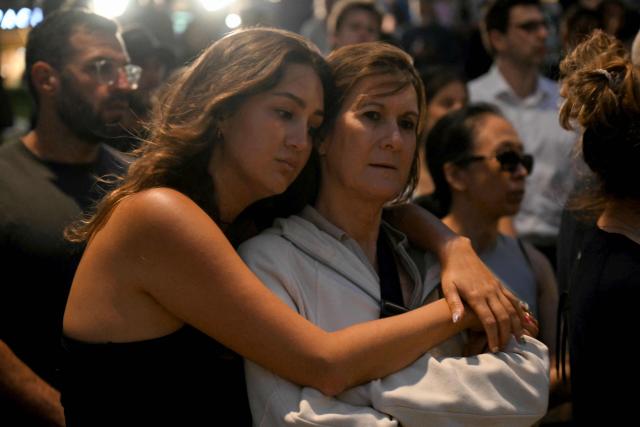 Mourners gather at a tribute at the Bondi Pavillion in memory of the victims of a shooting at Bondi Beach, in Sydney on December 15, 2025. A father and son opened fire on a Jewish festival at Australia's Bondi Beach in a shooting spree that killed 15 people, including a child, authorities said on December 15, denouncing the attack as antisemitic "terrorism". (Photo by Saeed KHAN / AFP)
