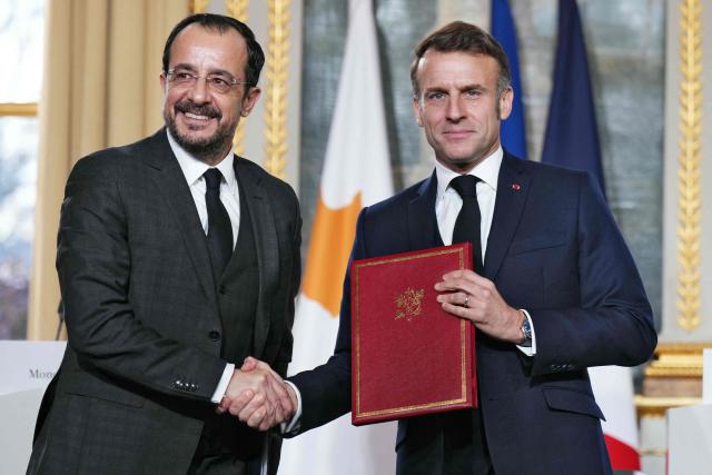 France's President Emmanuel Macron (R) shakes hands with Cyprus' President Nikos Christodoulides during a document signing ceremony following their meeting at the Elysee Palace in Paris, on December 15, 2025. (Photo by Dimitar DILKOFF / AFP)