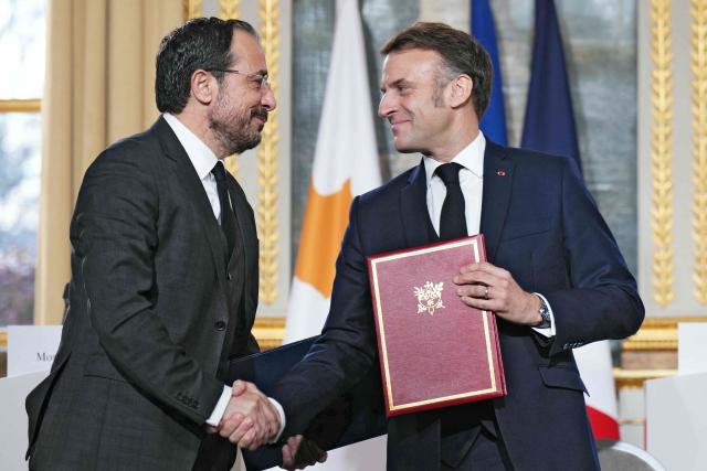 France's President Emmanuel Macron (R) shakes hands with Cyprus' President Nikos Christodoulides during a document signing ceremony following their meeting at the Elysee Palace in Paris, on December 15, 2025. (Photo by Dimitar DILKOFF / AFP)