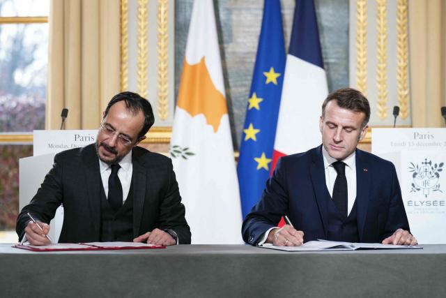 France's President Emmanuel Macron (R) and Cyprus' President Nikos Christodoulides take part in a document signing ceremony following their meeting at the Elysee Palace in Paris, on December 15, 2025. (Photo by Dimitar DILKOFF / AFP)
