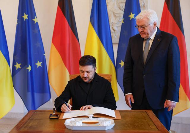 German President Frank-Walter Steinmeier watches as Ukraine's President Volodymyr Zelensky signs the guestbook at the presidential Bellevue Palace in Berlin, Germany, on December 15, 2025. Ukrainian President Volodymyr Zelensky was set to push on with talks in Berlin with US President Donald Trump's envoys on how to end the grinding war with Russia. (Photo by Odd ANDERSEN / AFP)