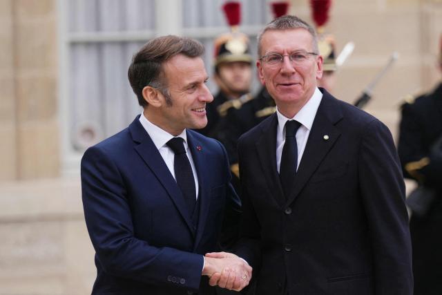 France's President Emmanuel Macron (L) greets Latvia's president Edgars Rinkevics prior to their meeting at the Elysee Palace in Paris, on December 15, 2025. (Photo by Dimitar DILKOFF / AFP)