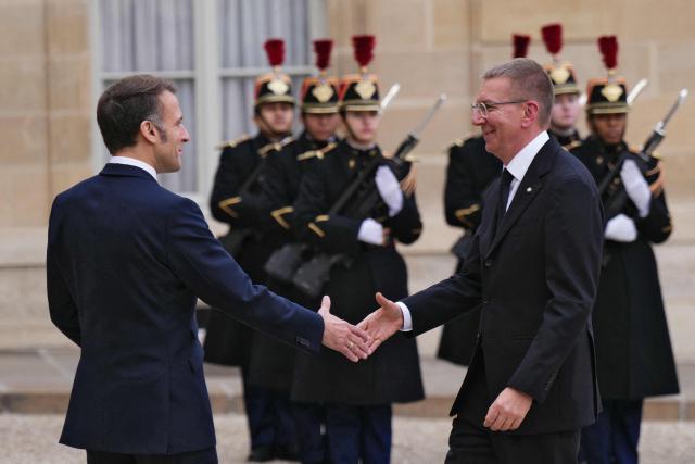 France's President Emmanuel Macron (L) greets Latvia's president Edgars Rinkevics prior to their meeting at the Elysee Palace in Paris, on December 15, 2025. (Photo by Dimitar DILKOFF / AFP)
