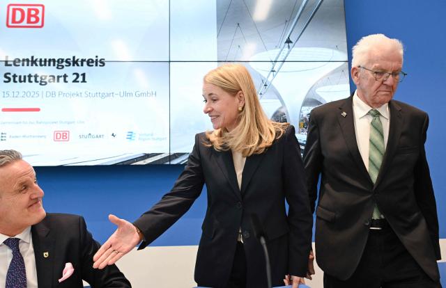 Evelyn Palla (L), CEO of German railways operator Deutsche Bahn (DB), Stuttgarts Lord Mayor Frank Nopper (L) and Baden-Wuerttemberg's State Premier Winfried Kretschmann attend a press conference of the Steering Committee on the rail project Stuttgart 21 at the Stuttgart airport in Stuttgart, southern Germany, on December 15, 2025. Palla announced internal investigations, after the inauguration of the mammoth railway project Stuttgart 21 has been delayed yet again. Work began 15 years ago on Stuttgart 21, which involves replacing the current station with a major underground site. But repeated delays have left the city centre resembling a building site, while costs have more than doubled to around 11 billion euros ($12.7 billion). (Photo by THOMAS KIENZLE / AFP)