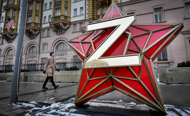 A man walks past a New Year decoration - the Kremlin star, bearing a Z letter, a tactical insignia of Russian troops in Ukraine, installed in front of the US Embassy in Moscow on December 15, 2025. US negotiators still want Ukraine to cede control of the eastern Donetsk and Lugansk regions as a condition for peace talks with Russia, an official briefed on the discussions told AFP on Monday. Kyiv is pushing back against Washington's demand that it pull troops from the two regions collectively known as Donbas, which Russia has been unable to capture since invading in February 2022. (Photo by Alexander NEMENOV / AFP)