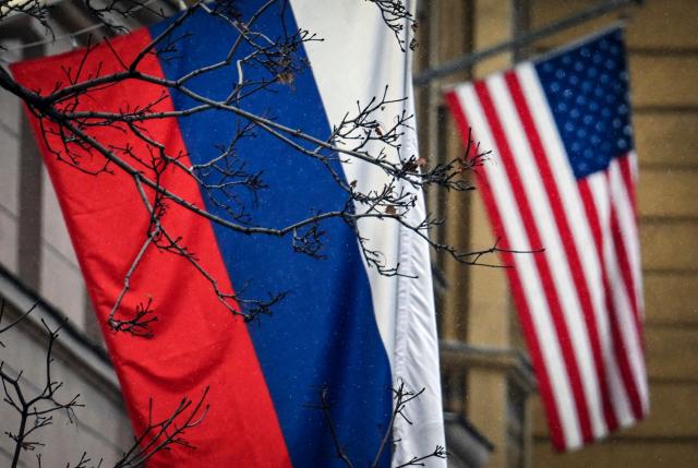 A Russian flag waves in front of a US flag seen at the US Embassy in Moscow on December 15, 2025. US negotiators still want Ukraine to cede control of the eastern Donetsk and Lugansk regions as a condition for peace talks with Russia, an official briefed on the discussions told AFP on Monday. Kyiv is pushing back against Washington's demand that it pull troops from the two regions collectively known as Donbas, which Russia has been unable to capture since invading in February 2022. (Photo by Alexander NEMENOV / AFP)