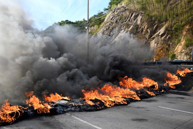 View of the CA-5 highway, which connects the capital with northern Honduras, blocked by supporters of the ruling Libertad y Refundación (LIBRE) party, in Tegucigalpa, on December 15, 2025. LIBRE called for protests in the streets to denounce electoral fraud and the interference of US President Donald Trump in the elections. Today marks two weeks since Hondurans have been waiting to find out who their next president will be, as they await a special recount that will determine the winner between conservative Nasry Asfura, supported by Donald Trump, and right-wing Salvador Nasralla. (Photo by Orlando SIERRA / AFP)