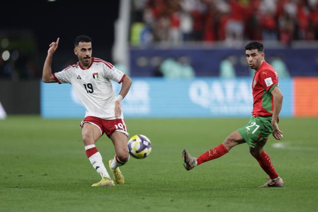 UAE’s defender #19 Khaled Aldhanhani (L) vies for the ball with Morocco's forward #21 Karim Al Berkaoui (R) during the FIFA Arab Cup 2025 semi-final football match between Morocco and the United Arab Emirates at the Khalifa International Stadium in Al-Rayyan on December 15, 2025. (Photo by KARIM JAAFAR / AFP)