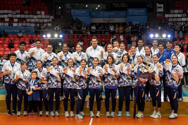Thailand's players showing their gold medals pose for photographs after winning the women's volleyball final match of the 33rd Southeast Asian Games (SEA Games) against Vietnam at Huamark Indoor Stadium in Bangkok on December 15, 2025. (Photo by Chanakarn Laosarakham / AFP)