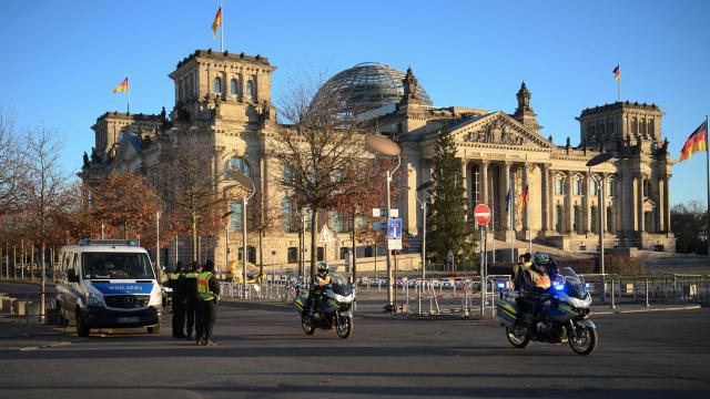 Police are seen in front of the Reichstag building, seat of the German lower house of parliament Bundestag, in the governmental district near the Chancellery in Berlin, Germany, on December 15, 2025, during a visit of the Ukrainian President. The Ukrainian President travelled to Berlin to meet European leaders as well as US President Donald Trump's envoy, the heads of the EU and NATO for talks. (Photo by RALF HIRSCHBERGER / AFP)
