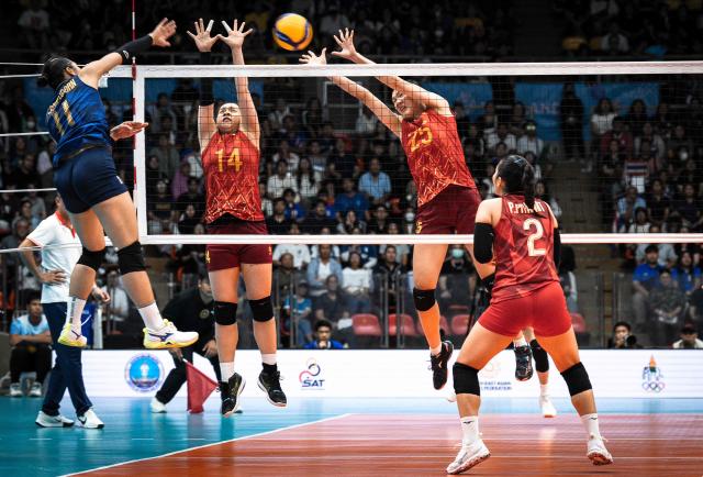 Vietnam's VO Thi Kim Thoa (L) and TRAN Thi Bich Thuy (R) attempt to block the ball against Thailand during the women's volleyball final match of the 33rd Southeast Asian Games (SEA Games) at Huamark Indoor Stadium in Bangkok on December 15, 2025. (Photo by Chanakarn Laosarakham / AFP)