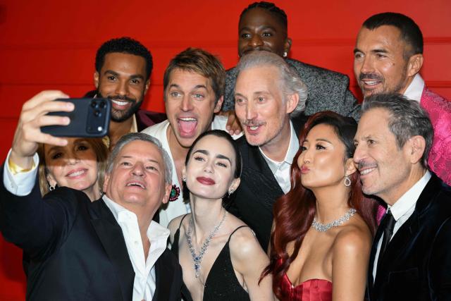 (From Top L) Netflix CEO Ted Sarandos takes a selfie with French actress Philippine Leroy-Beaulieu, British actor Lucien Laviscount, French actor Lucas Bravo, US actress Lily Collins French actor Bruno Gouery, French actor Samuel Arnold, US actress Ashley Park, US director producer and screenwriter Darren Star and French actor William Abadie during the avant-premiere of TV serie "Emily in Paris" season 5, at the Grand Rex, in Paris on December 15, 2025. (Photo by Blanca CRUZ / AFP)