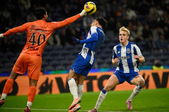 Estrela da Amadora's Brazilian goalkeeper #40 Renan Ribeiro clears the ball next to FC Porto's Brazilian forward #11 Pepe (C) and FC Porto's Danish midfielder #08 Victor Froholdt (R) during the Portuguese league football match between FC Porto and CF Estrela da Amadora at Dragao stadium in Porto on December 15, 2025. (Photo by Miguel RIOPA / AFP)