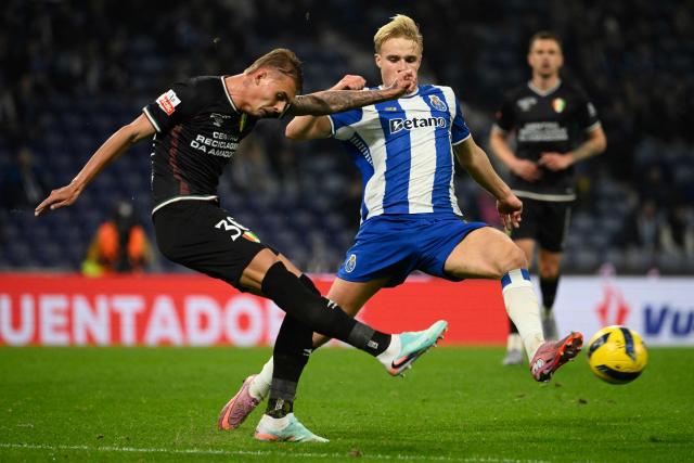 Estrela da Amadora's Brazilian defender #30 Luan Patrick (L) and FC Porto's Danish midfielder #08 Victor Froholdt fight for the ball during the Portuguese league football match between FC Porto and CF Estrela da Amadora at Dragao stadium in Porto on December 15, 2025. (Photo by Miguel RIOPA / AFP)