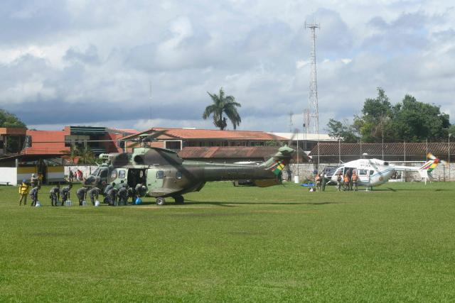 Soldiers of the Bolivian Army load food and water into a helicopter for affected people after the Pirai River overflowed due to heavy rains, at the Municipal Coliseum in El Torno, Santa Cruz department, Bolivia on December 15, 2025. At least 20 people were killed and dozens remain missing after a major river in eastern Bolivia burst its banks at the weekend following heavy rains, authorities said Monday. (Photo by Rodrigo URZAGASTI / AFP)