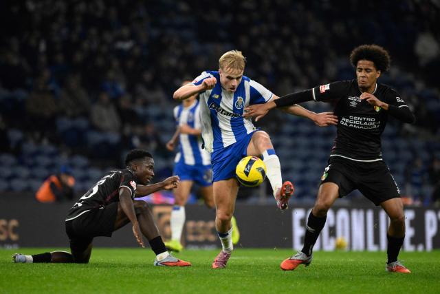 (From L) Estrela da Amadora's Angolan midfielder #63 Alexandre Mussolo Sola, FC Porto's Danish midfielder #08 Victor Froholdt and Estrela da Amadora's French midfielder #06 Oumar Hgom fight for the ball during the Portuguese league football match between FC Porto and CF Estrela da Amadora at Dragao stadium in Porto on December 15, 2025. (Photo by Miguel RIOPA / AFP)