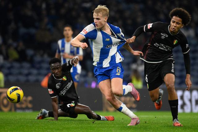 (From L) Estrela da Amadora's Angolan midfielder #63 Alexandre Mussolo Sola, FC Porto's Danish midfielder #08 Victor Froholdt and Estrela da Amadora's French midfielder #06 Oumar Hgom fight for the ball during the Portuguese league football match between FC Porto and CF Estrela da Amadora at Dragao stadium in Porto on December 15, 2025. (Photo by Miguel RIOPA / AFP)