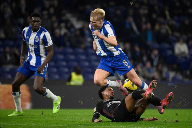 FC Porto's Danish midfielder #08 Victor Froholdt (TOP) fights for the ball with Estrela da Amadora's Portuguese defender #83 Otavio Otavio (BOTTOM) during the Portuguese league football match between FC Porto and CF Estrela da Amadora at Dragao stadium in Porto on December 15, 2025. (Photo by Miguel RIOPA / AFP)