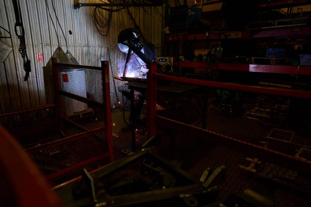 A welder works on a part of a snowplow at Arctic Snowplows in London, Ontario, on December 10, 2025. For decades, Arctic Snowplows has sold its Canadian-made galvanized steel products to "anywhere there is snow" across the border in the United States, says company boss Mike Schulz. But a year into President Donald Trump's trade war, some of those customers have been lost, with buyers unwilling to stomach higher prices forced by US tariffs on imported steel. "Adding an extra $500 (US$363) on the cost of a $10,000 plow, it's a huge hit," Schulz told AFP, as a heavy snow fell outside the company's factory in London, Ontario, 190 kilometers (120 miles) southwest of Toronto. (Photo by Geoff Robins / AFP)