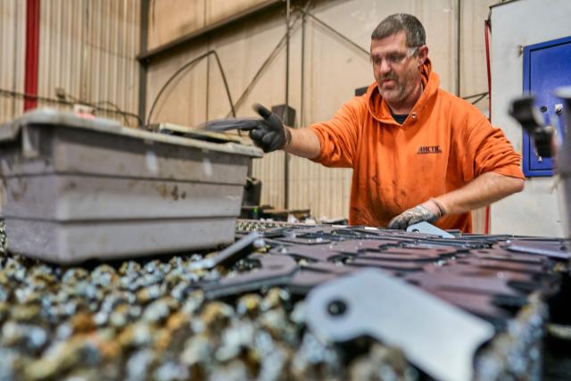 A worker collects laser-cut parts for a snow plow at Arctic Snowplows in London, Ontario, on December 10, 2025. For decades, Arctic Snowplows has sold its Canadian-made galvanized steel products to "anywhere there is snow" across the border in the United States, says company boss Mike Schulz. But a year into President Donald Trump's trade war, some of those customers have been lost, with buyers unwilling to stomach higher prices forced by US tariffs on imported steel. "Adding an extra $500 (US$363) on the cost of a $10,000 plow, it's a huge hit," Schulz told AFP, as a heavy snow fell outside the company's factory in London, Ontario, 190 kilometers (120 miles) southwest of Toronto. (Photo by Geoff Robins / AFP)