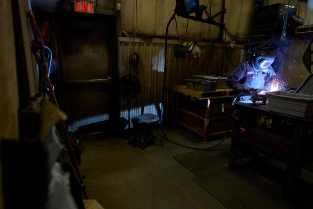 A welder works on a part of a snow plow at Arctic Snowplows in London, Ontario, on December 10, 2025. For decades, Arctic Snowplows has sold its Canadian-made galvanized steel products to "anywhere there is snow" across the border in the United States, says company boss Mike Schulz. But a year into President Donald Trump's trade war, some of those customers have been lost, with buyers unwilling to stomach higher prices forced by US tariffs on imported steel. "Adding an extra $500 (US$363) on the cost of a $10,000 plow, it's a huge hit," Schulz told AFP, as a heavy snow fell outside the company's factory in London, Ontario, 190 kilometers (120 miles) southwest of Toronto. (Photo by Geoff Robins / AFP)