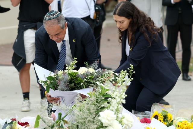 Israeli Ambassador to Australia Amir?Maimon (L) lays flowers at the Bondi Pavilion memorial in Sydney on December 16, 2025, honoring the victims of the Bondi Beach shooting. A father-and-son team toting long-barrelled guns shot and killed 15 people including a 10-year-old girl at Sydney's Bondi Beach on December 14, with authorities labelling it an antisemitic terrorist attack on a Jewish festival. (Photo by DAVID GRAY / AFP)