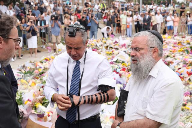 Israeli Ambassador to Australia Amir?Maimon (C) prays at the Bondi Pavilion memorial in Sydney on December 16, 2025, in tribute to victims of the Bondi Beach shooting. A father-and-son team toting long-barrelled guns shot and killed 15 people including a 10-year-old girl at Sydney's Bondi Beach on December 14, with authorities labelling it an antisemitic terrorist attack on a Jewish festival. (Photo by DAVID GRAY / AFP)