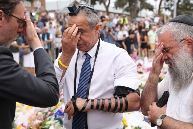 Israeli Ambassador to Australia Amir?Maimon (C) prays at the Bondi Pavilion memorial in Sydney on December 16, 2025, in tribute to victims of the Bondi Beach shooting. A father-and-son team toting long-barrelled guns shot and killed 15 people including a 10-year-old girl at Sydney's Bondi Beach on December 14, with authorities labelling it an antisemitic terrorist attack on a Jewish festival. (Photo by DAVID GRAY / AFP)