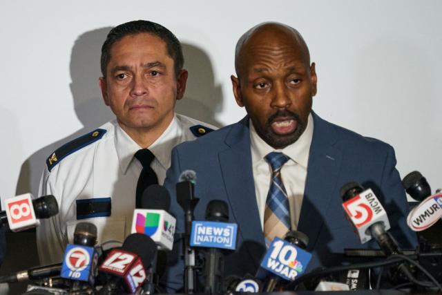 FBI Boston Special Agent-in-Charge Ted Docks speaks as  Providence Chief of Police Colonel Oscar Lopez listens during a press conference into the investigation into the December 13 mass shooting at Brown University, at the Providence Public Safety Complex in Providence, Rhode Island, on December 15, 2025. A gunman remained at large after a weekend mass shooting at elite Brown University left two dead and nine wounded, with US authorities releasing new footage of a masked "person of interest" captured on surveillance cameras. The shooting took place Saturday in a building where exams were underway on the Ivy League campus in Providence, Rhode Island when a man with a rifle burst in and opened fire before fleeing. (Photo by Bing Guan / AFP)
