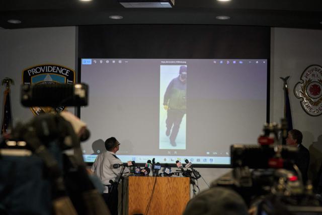 Colonel Oscar Perez (L), chief of the Providence Police Department, projects an image of a "person of interest" in the December 13 mass shooting at Brown University during a press conference at the Providence Public Safety Complex in Providence, Rhode Island, on December 15, 2025. A gunman remained at large after a weekend mass shooting at elite Brown University left two dead and nine wounded, with US authorities releasing new footage of a masked "person of interest" captured on surveillance cameras. The shooting took place Saturday in a building where exams were underway on the Ivy League campus in Providence, Rhode Island when a man with a rifle burst in and opened fire before fleeing. (Photo by Bing Guan / AFP)