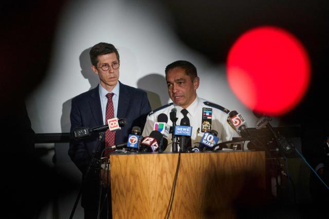 Colonel Oscar Perez, chief of the Providence Police Department, speaks as Providence Mayor Brett Smiley (L), looks on during a press conference into the ongoing investigation into the December 13 mass shooting at Brown University, at the Providence Public Safety Complex in Providence, Rhode Island, on December 15, 2025. A gunman remained at large after a weekend mass shooting at elite Brown University left two dead and nine wounded, with US authorities releasing new footage of a masked "person of interest" captured on surveillance cameras. The shooting took place Saturday in a building where exams were underway on the Ivy League campus in Providence, Rhode Island when a man with a rifle burst in and opened fire before fleeing. (Photo by Bing Guan / AFP)